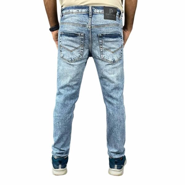 Backside view of model wearing Vintage Blue Jeans, highlighting the fit and design details