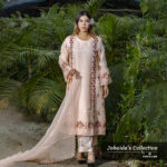 Woman wearing a blush pink embroidered muslin-silk 3-piece suit with floral detailing, holding a scalloped dupatta, standing in a garden setting.
