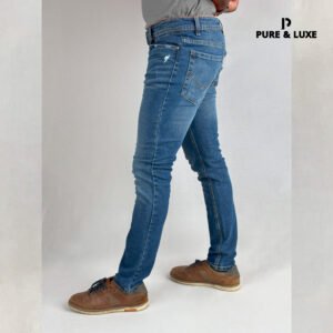 Man wearing Hard Grind Indigo Slim Fit Jeans by Pure & Luxe – left leg view